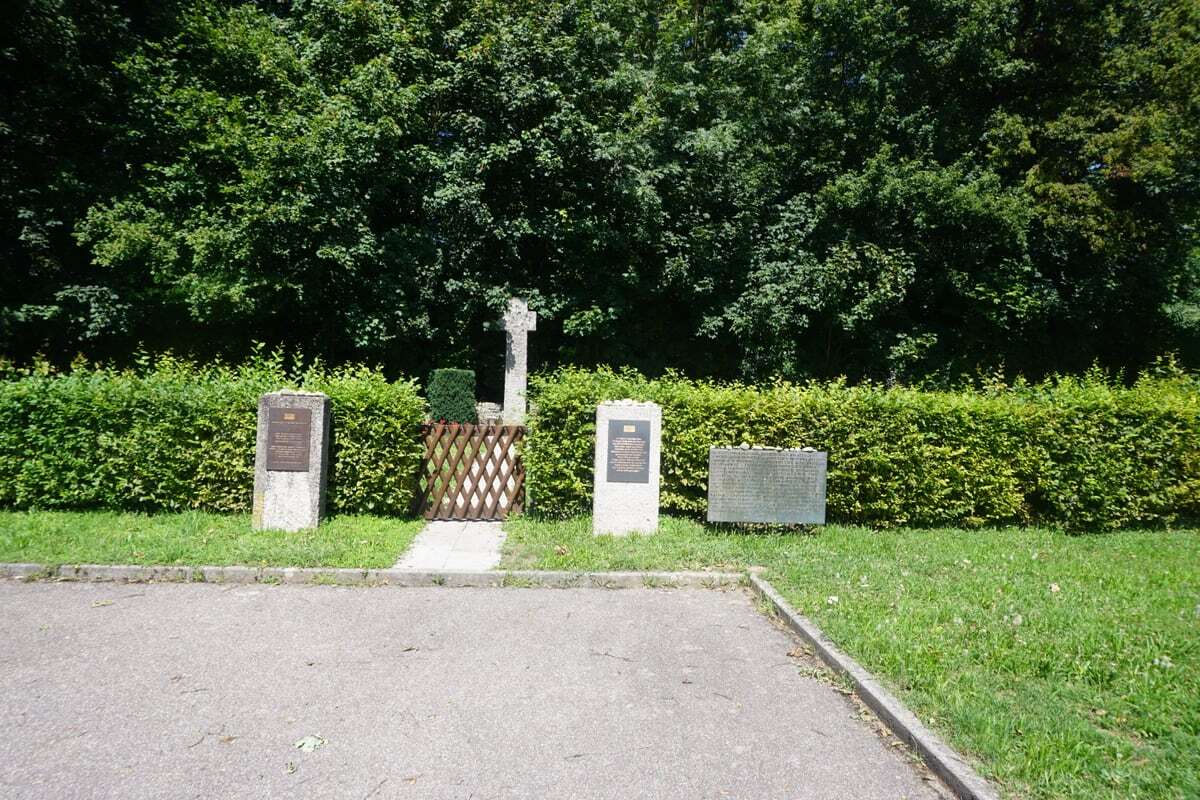 Wejście na cmentarz KZ-Friedhof Kochendorf w Bad Friedrichshall: drewniana bramka, tablice i krzyż w głębi