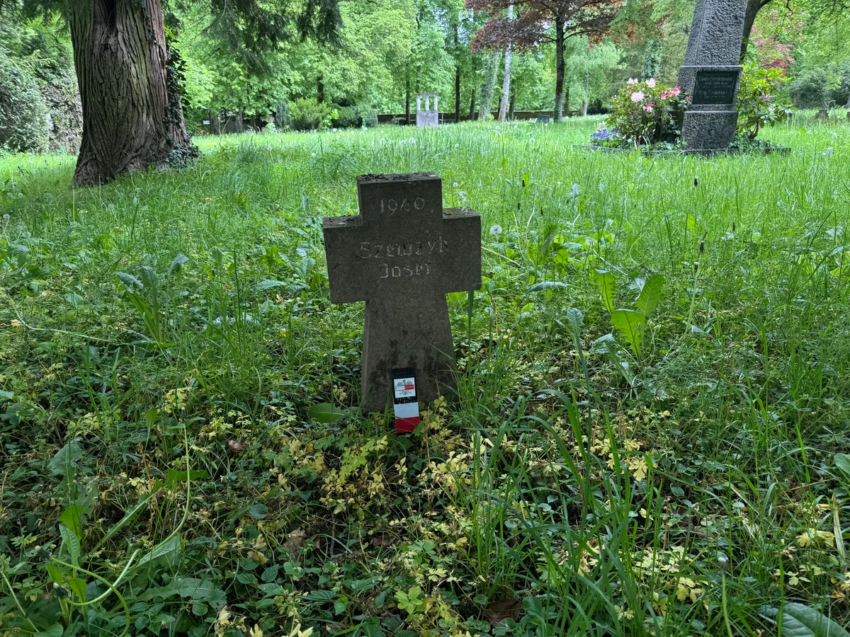 Kamienny krzyż Józefa Szewczyka ze zniczem Ostoi.
