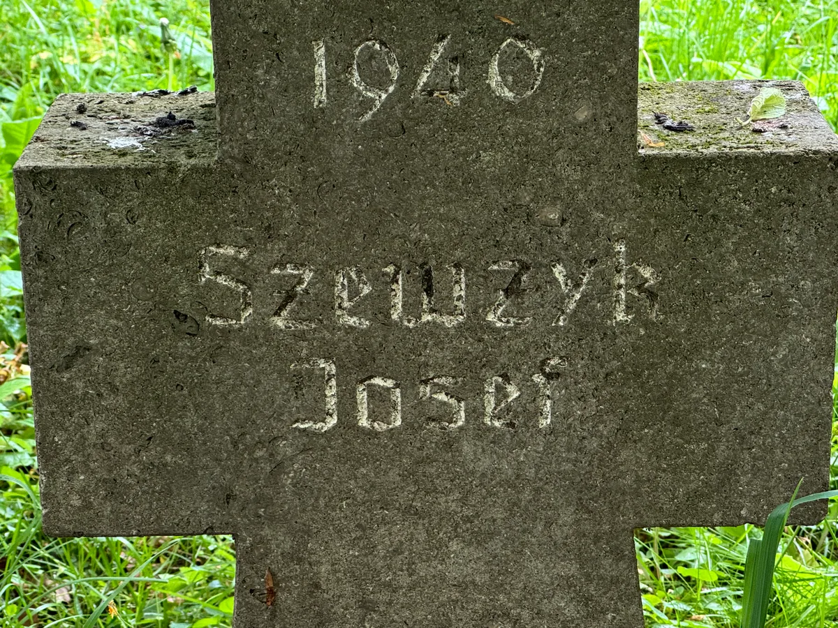 Krzyż J. Szewczyka — zbliżenie napisu.