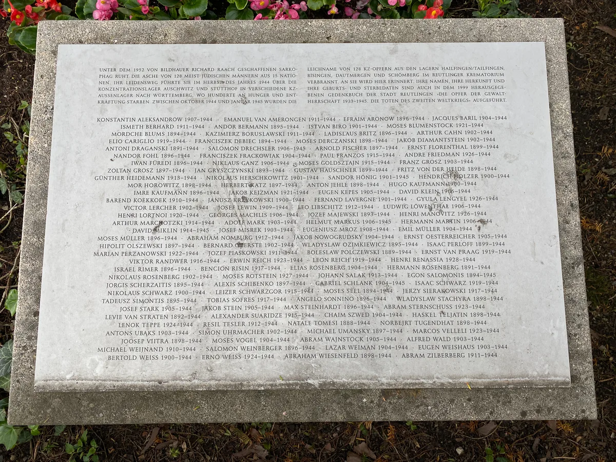 Tablica z nazwiskami 128 ofiar KZ (Hailfingen/Tailfingen, Bisingen, Dautmergen, Schömberg), których prochy spoczywają pod sarkofagiem.
Napis: „Unter dem 1952 von Bildhauer Richard Raach geschaffenen Sarkophag ruht die Asche von 128 meist jüdischen Männern aus 15 Nationen. Ihr Leidensweg führte sie im Herbst des Jahres 1944 über die Konzentrationslager Auschwitz und Stutthof in verschiedene KZ-Aussenlager nach Württemberg, wo Hunderte an Hunger und Entkräftung starben. Zwischen Oktober 1944 und Januar 1945 wurden die Leichname von 128 KZ-Opfern aus den Lagern Hailfingen/Tailfingen, Bisingen, Dautmergen und Schömberg im Reutlinger Krematorium verbrannt. An sie wird hier erinnert. […] (dalej 128 nazwisk z latami życia)”